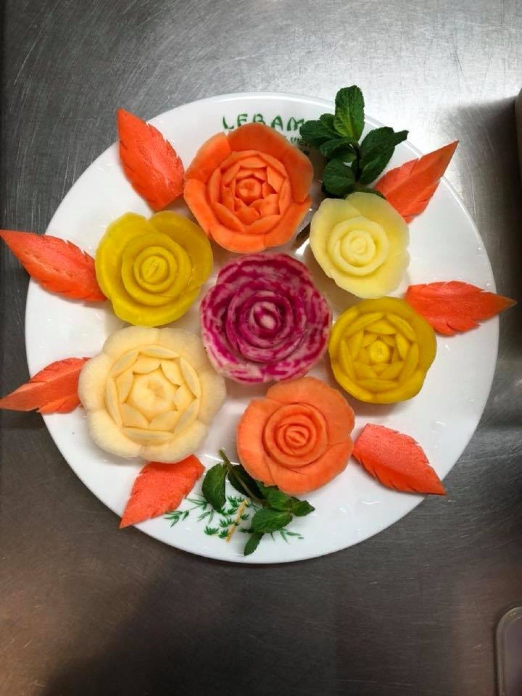 Une assiette de plats aux légumes sculptés en fleurs orange et jaunes